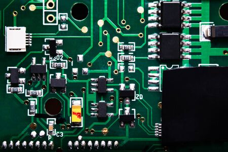 A close-up microchip with many electrical components placed on the Board. The background is blurred.の写真素材