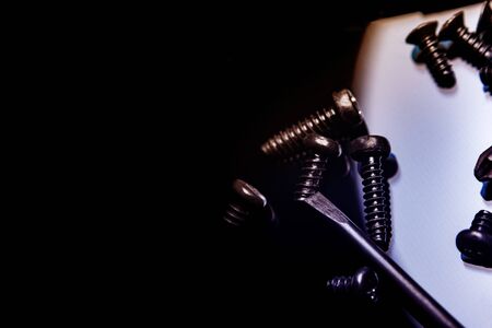 Black screws on a dark background. Screws scattered in a chaotic manner. Table glossy black.の写真素材