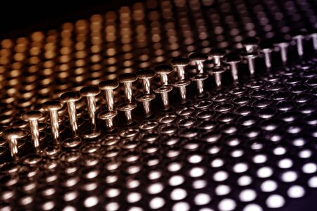 A lot of shiny little nails on a dark background arranged tightly together. Shallow depth of field.の写真素材