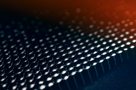 A lot of shiny little nails on a dark background arranged tightly together. Shallow depth of field.