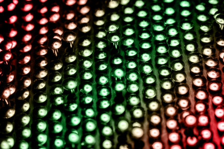 A lot of shiny little nails on a dark background arranged tightly together. Shallow depth of field.