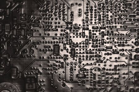 A close-up microchip with many electrical components placed on the Board. The background is blurred.の写真素材