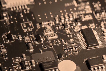 A close-up microchip with many electrical components placed on the Board. The background is blurred.の写真素材