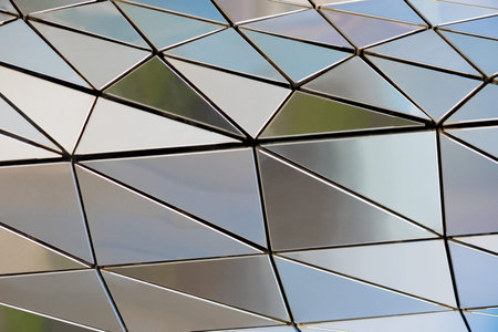A metal wall made of many triangles. Triangles with sharp corners and gradient transitions.