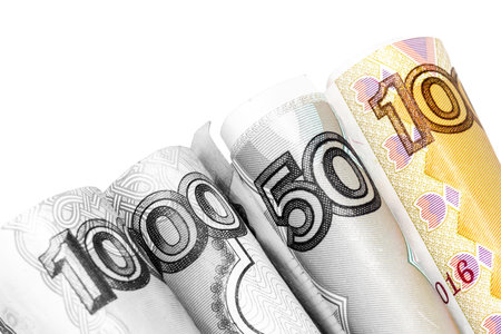Rolled banknote of rubles of different denominations on a white background photographed close.