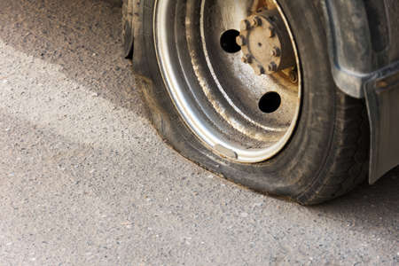 Blown away a dirty rusty car wheel truck. There are signs of deliberate damage to the wheel.の写真素材