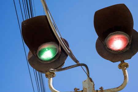 Railway old dirty rusty traffic light against a clear sky. Visible dirt wires and rust.