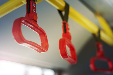 Handles on public transport during the day. There is no one in transport. The background is blurred.