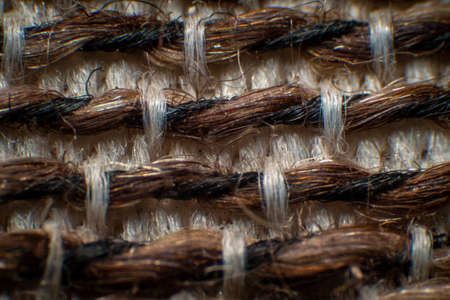 Synthetic fabric fibers for chairs, coarse fabrics, with gaps between fibers. Neat weave Large white-brown fibers , High magnification , Super macro.の写真素材