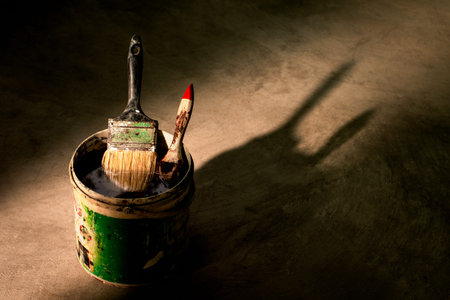 The old paint brush has been used and then soaked in a clean container