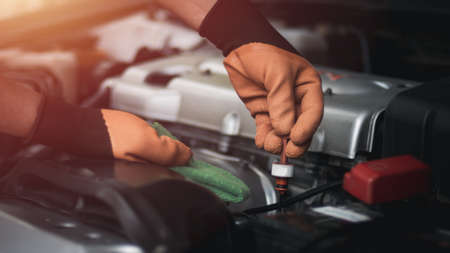 Auto mechanic working in garage. Repair service.Pull and check engine oil level.の写真素材