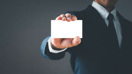 Businessman's Hand hold blank white card mockup with rounded corners. Plain call-card mock up template holding arm. Plastic credit card, namecard display front. Business branding.の写真素材