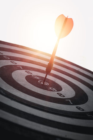 A red dart is placed in the center of a circular target. Communicate the business success of the...
