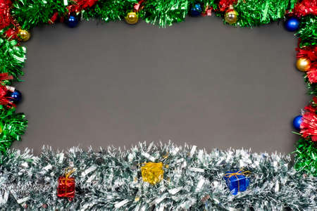 Christmas border template with fir branches, Beautiful red green blue and gold toys and ribbon,on space gray color background, Merry Christmas and Happy New Year.の写真素材