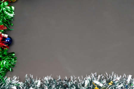 Christmas border template with fir branches, Beautiful red green blue and gold toys and ribbon,on space gray color background, Merry Christmas and Happy New Year.の写真素材