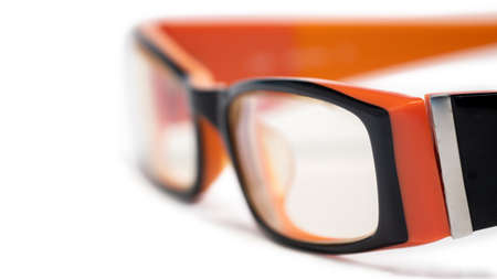 Orange glasses with black frame lenses placed on a white backgroundの写真素材