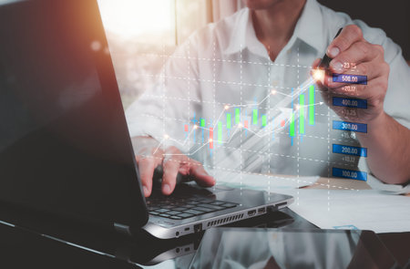 The concept is a stock market investment, businessmen using laptop computers and digital tablets...