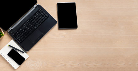 Laptop computer, tablet computer, and mobile phone blank screen on wood table background, mockup,...