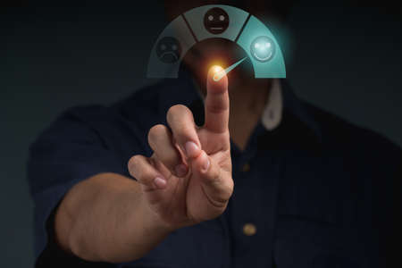The businessman uses finger point to smiling face icon for customer services best excellent business rating experience. Satisfaction survey concept.の写真素材