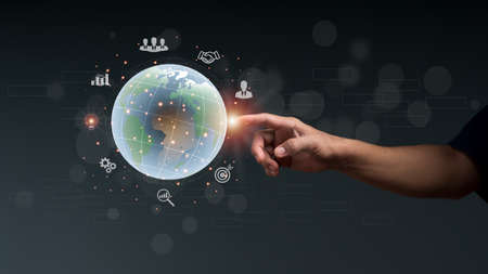 Businessman points to the globe with business icons all around, Business global big data, internet connection application Digital link technology and digital marketing, Financial and banking concept.の写真素材
