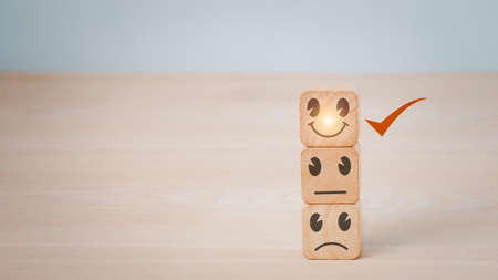 Customer services best excellent business rating experience. Satisfaction survey concept.Chooses a smile face on wood block cube.の写真素材