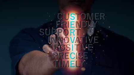A businessman holds out his hand to hold a glowing sign with customer service letters.の写真素材