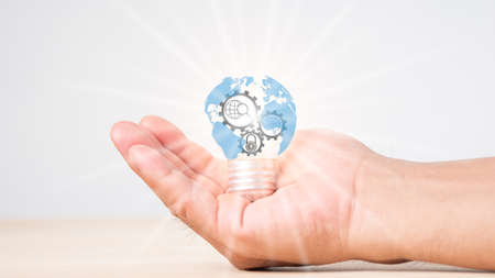 Creative light bulb with world map, growth graph, banking icons. Financial innovation technology develops new products, services that enhance success, profit in global business.の写真素材