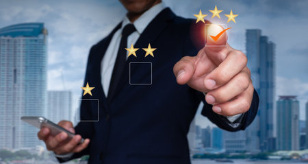 A guy points with finger and selects a three-star emoji to display on the virtual screen. A survey, poll,or questionnaire designed to gather information about user experience or customer satisfaction.の写真素材