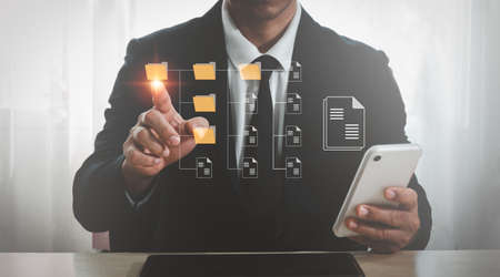 An IT specialist in the workplace is installing a Document Management System (DMS) on a laptop computer. File archiving software for businessesの写真素材