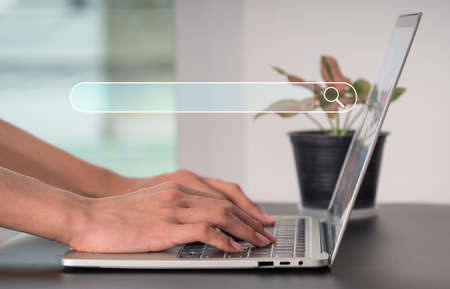 SEARCH ENGINE OPTIMIZATION (SEO)The notion of SEO networking. A search browser of Internet data information is provided with a blank search box. On his laptop, a businesswoman scans the internet.の写真素材