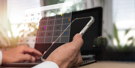 A man His right hand phone was showing Appointment Reminder for the Calendar and the Organizer's Agenda. Event planners utilize timetables to schedule events.の写真素材