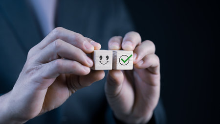 a man uses a wood cube and chooses a face smile emoticon to show on the virtual screenã Surveys, polls or user experience, or customer satisfaction questionnaires.の写真素材