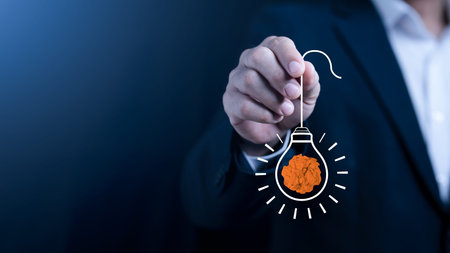 Creative idea and innovation concept, business hand holding light bulb with paper brain metaphor,...