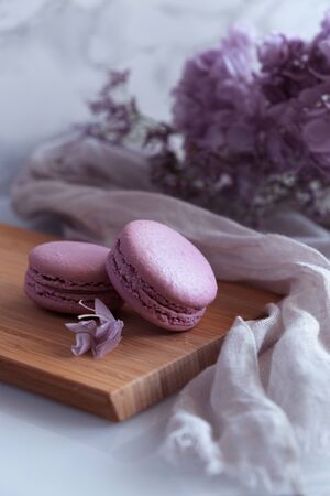Composition with violet macaroons with bouquet of violet flowersの写真素材