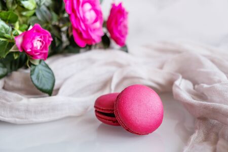 Strawberry macarons with roses on white backgroundの写真素材