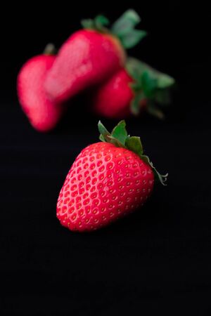 Strawberries with strawberry leaf on black backgroundの写真素材