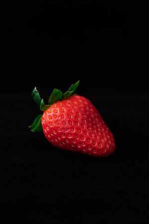 Strawberry with strawberry leaf on black backgroundの写真素材