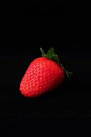 Strawberry with strawberry leaf on black backgroundの写真素材