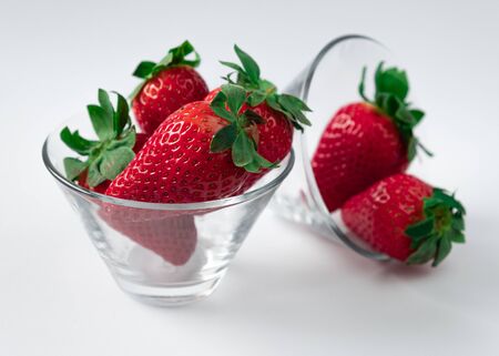Strawberries with strawberry leaf in cristal bowl on white backgroundの写真素材