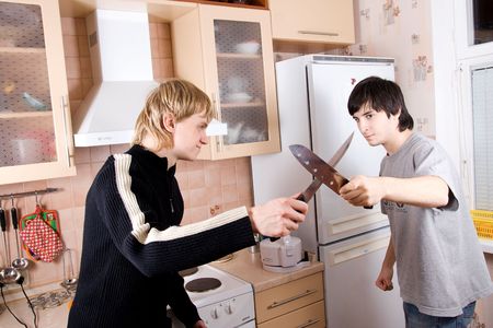Two guys fight with knifes on kitchen.の写真素材