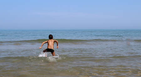 Child running in the sea - funの写真素材