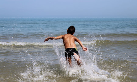 Child running in the sea - fun