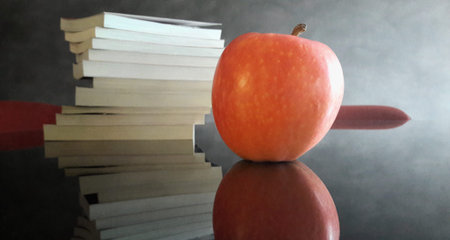 Books and a red apple on the desk