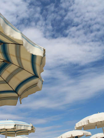 Umbrellas on the beach by the sea in summerの写真素材