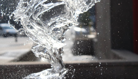 Splashing water from a fountain in the city in spring