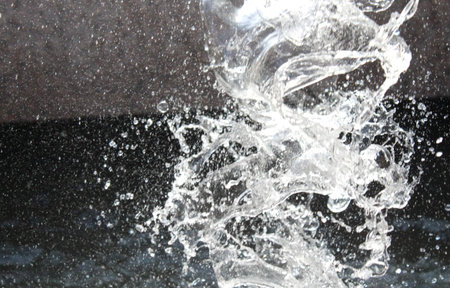 Splashing water from a fountain in the city in spring