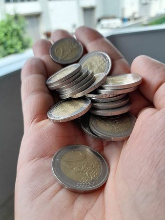 2 euro coins in the hands of a man