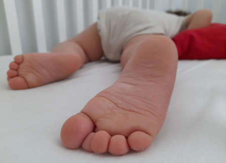 Foot of a baby in his crib while he is sleepingの写真素材