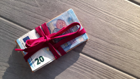 Wad of Euro banknotes tied with a ribbonの写真素材