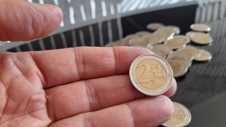 2 euro coins in the hands of a man